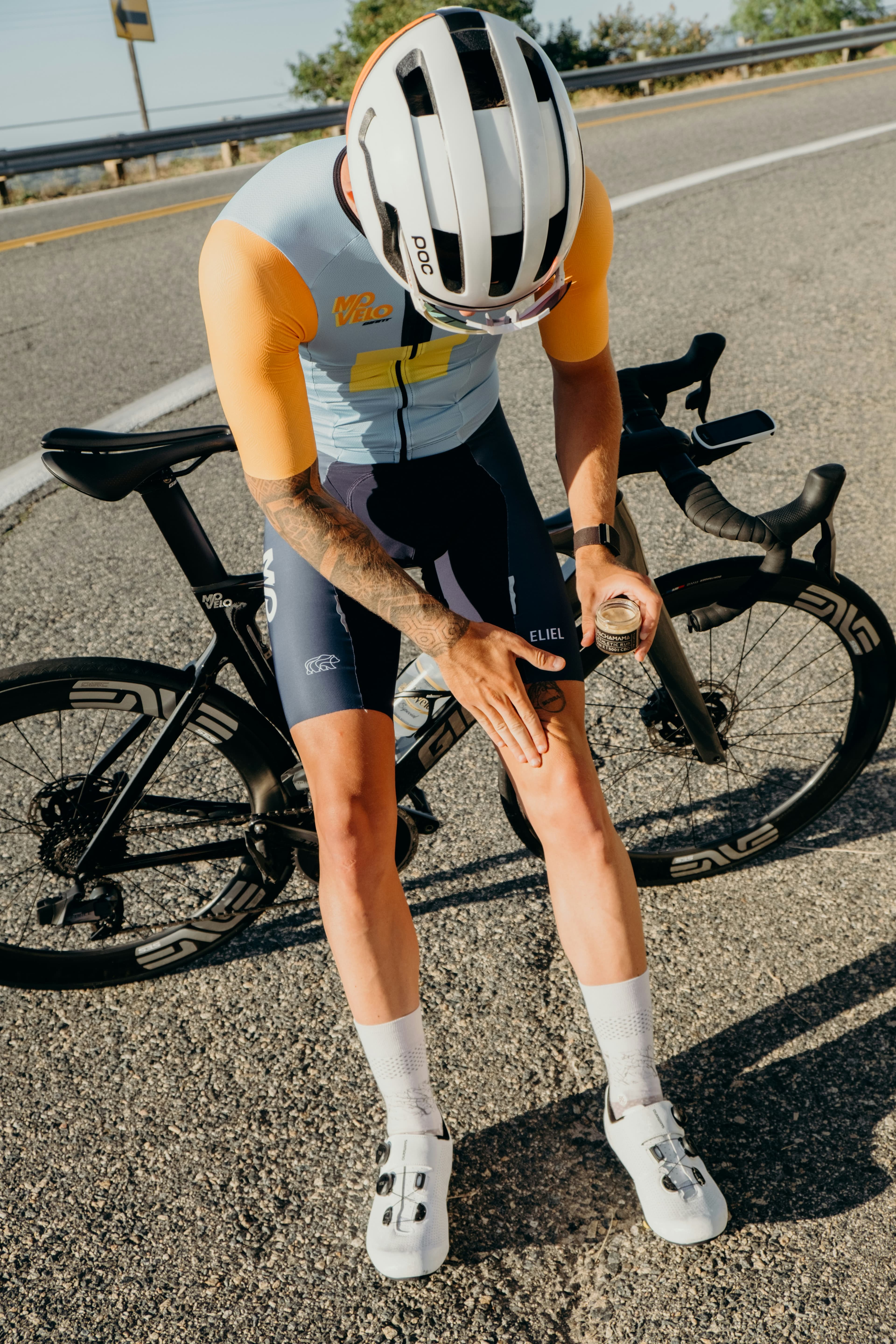A cyclist resting over the bike on an open road