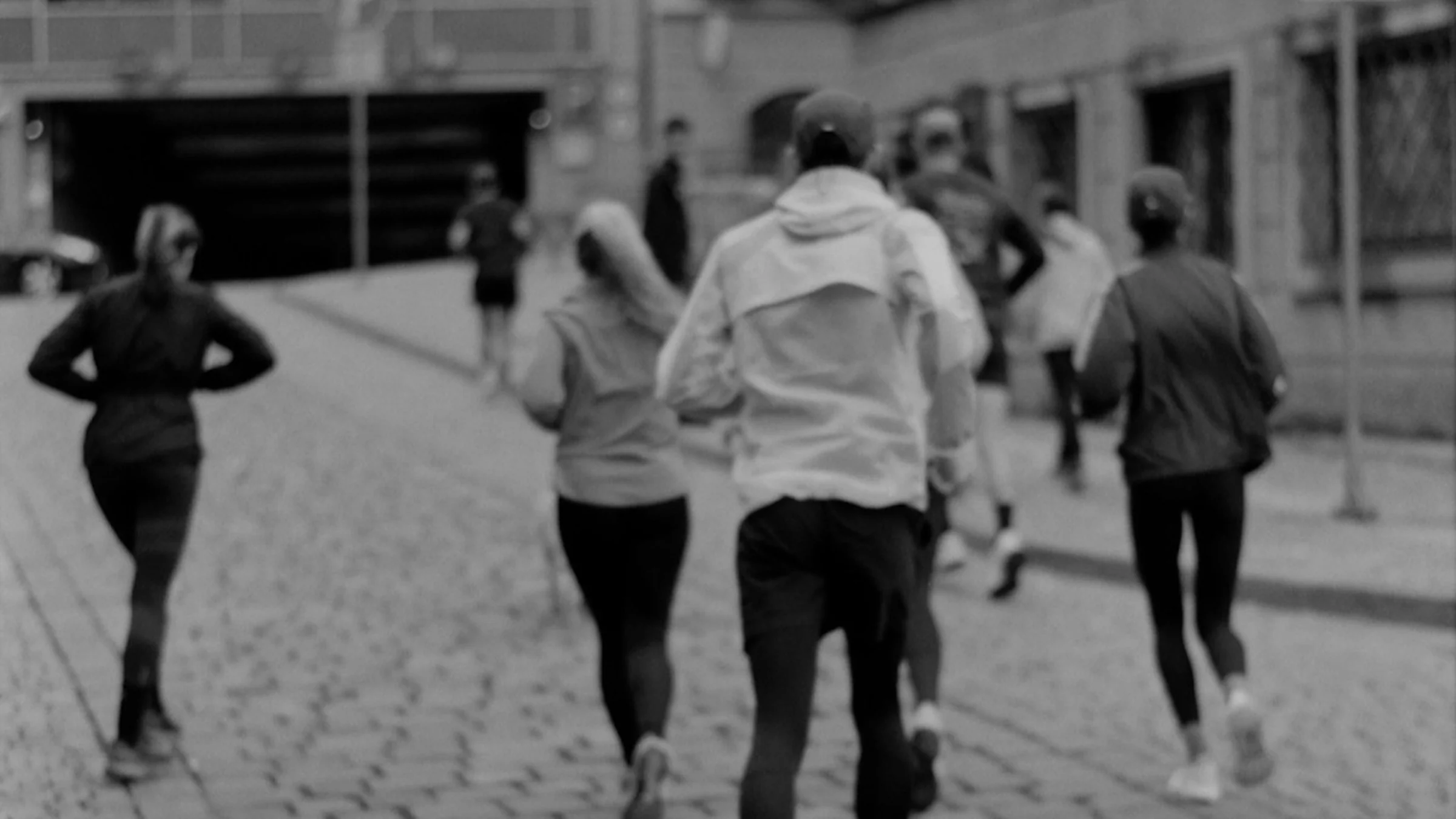 A run club training together through cobblestone city streets